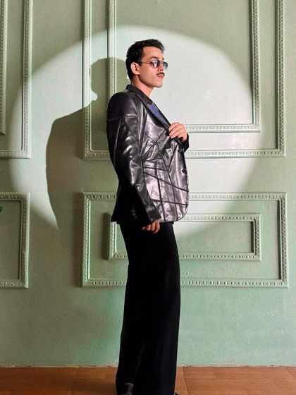 Giri Sawalkar commands attention in the Enigma Set, a masterpiece of bold patterns and sleek leather. The structured design brings a sharp, modern edge to the classic black suit.