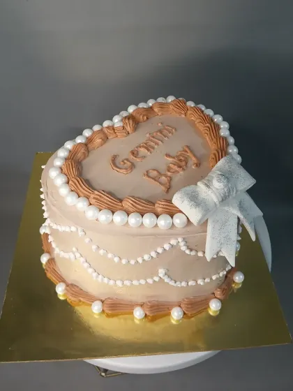 A vintage-style heart-shaped cake for a "Gemini Baby."