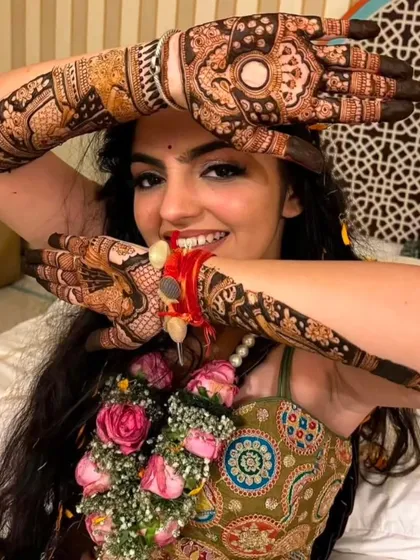 A fun and candid shot of a bride playfully showing off her intricate bridal mehndi.