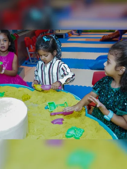Kids engaged in sensory play at the sand table, a great activity for younger guests.
