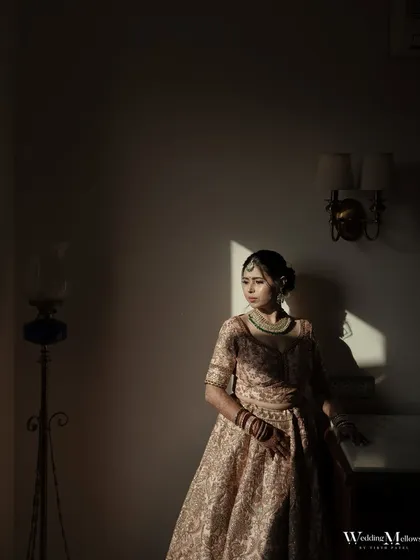 An artistic bridal portrait using shadows and light. The bride stands in a sliver of sunlight, creating a dramatic and contemplative mood that is absolutely captivating.