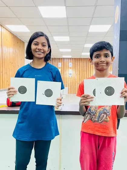 Two young campers showing off their targets after a session. This simple, joyful image captures the essence of finding a new skill and having fun while doing it.