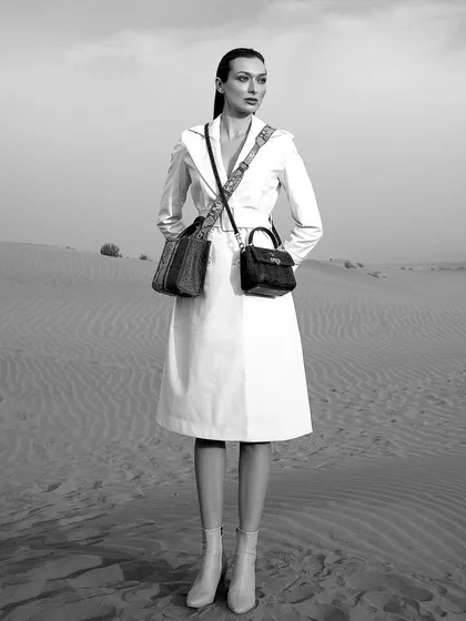 Shot in the desert for a luxury accessories brand, this black and white image creates a narrative of stark, minimalist elegance. The styling of the leather trench coat and dual bags against the vast landscape was a deliberate choice to evoke a sense of timeless adventure and high fashion.