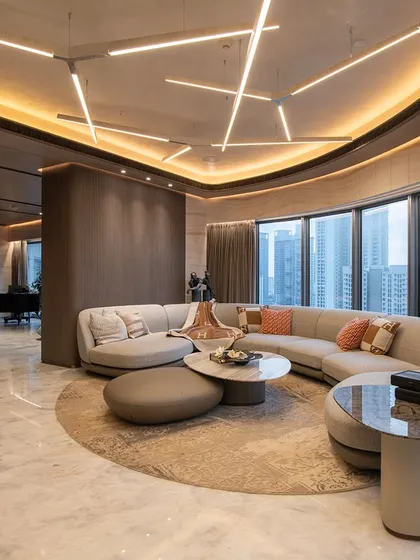 This living room at Lodha World View Apartments in Mumbai redefines luxury living. The design follows the building's signature curves, creating a seamless flow, while expansive windows invite natural light and frame breathtaking city views.