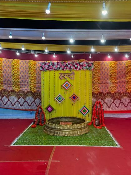 A centered view of the Haldi decoration, showing the symmetry of the backdrop and the surrounding pandal.