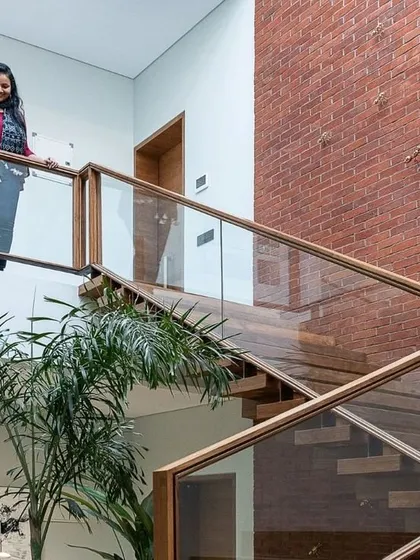 A personal touch, showing me on the glass-railed bridge overlooking the indoor greenery. It demonstrates the scale and multi-level experience of the homes I design.