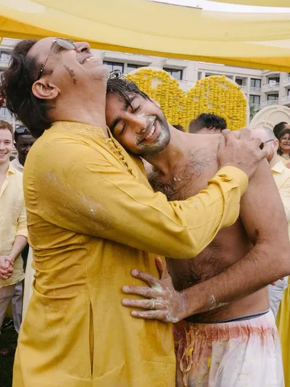A father and son share a heartfelt hug during the haldi ceremony. The emotion is palpable, a moment of pure love and connection between two generations.