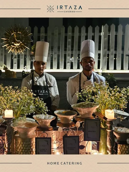 A professional home catering setup with two of my chefs ready for service. The clean white chef coats and the beautifully arranged food station reflect my commitment to high standards.
