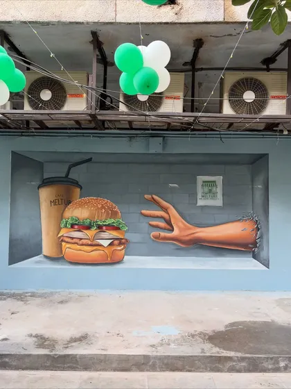A closer view of the food and hand elements of the 3D cafe mural. The goal was to make the burger look so real you could almost grab it, creating a playful and appetizing visual.