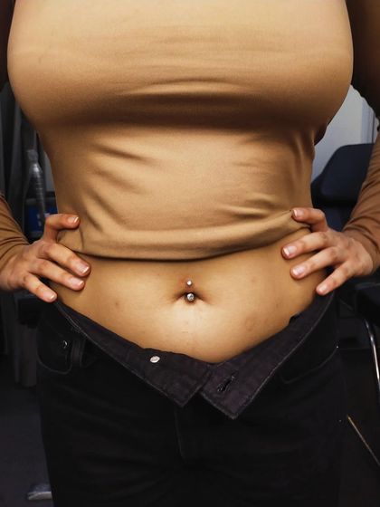 A fresh navel piercing with a classic crystal barbell. I ensure the placement is correct for your specific anatomy.