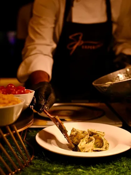 A chef carefully plates a serving of three-cheese stuffed tortellini, ensuring an elegant presentation for each guest.