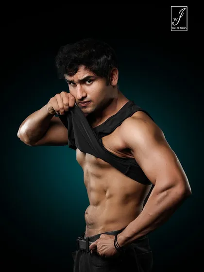 An intense, direct gaze at the camera while lifting the shirt to reveal a chiseled core. This is a powerful and confident shot, perfect for showcasing the results of a body transformation.