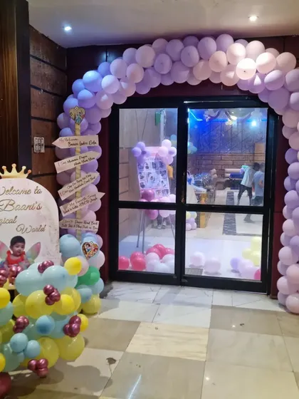 The entrance to a princess-themed party, featuring a large pastel balloon arch and a welcome sign.