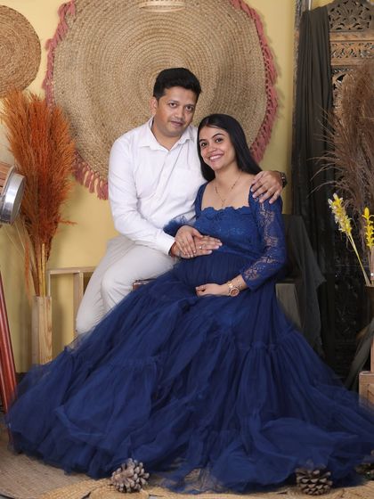 A beautiful couple's portrait from a glamorous studio session. The partner’s embrace adds a sense of warmth and support, perfectly complementing the elegance of the maternity gown.