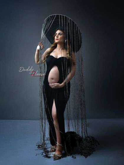 A highly creative and avant-garde maternity portrait. The mom-to-be wears a unique headpiece that creates a "rain" effect, resulting in a truly artistic and memorable photo.