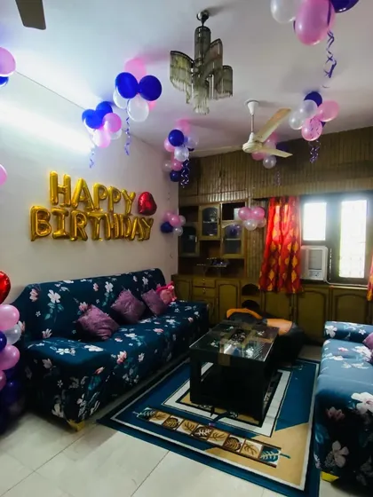 A wider view of the cozy living room birthday decoration, showing the full space.