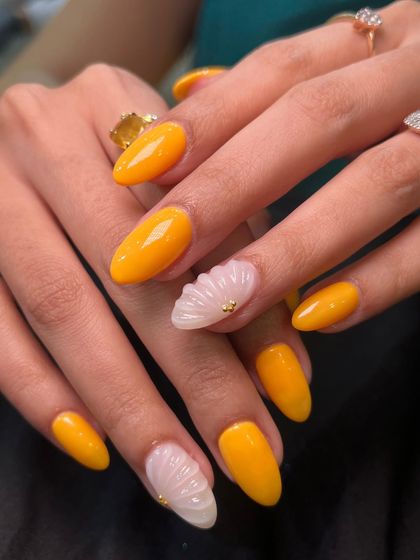 A bright and cheerful yellow set with seashell-textured accent nails. The tiny gold studs add a perfect finishing touch.