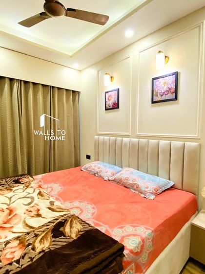 A cozy and elegant bedroom from the Chatterjee home. I used a neutral color palette, a comfortable bed with a vertically-paneled headboard, and classic wall mouldings with accent lights to create a timeless and peaceful retreat.