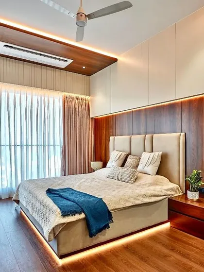Beautiful and timeless is what we aim for. This bedroom showcases a serene combination of materials, with a wood-paneled feature wall, a simple upholstered headboard, and subtle under-bed lighting.