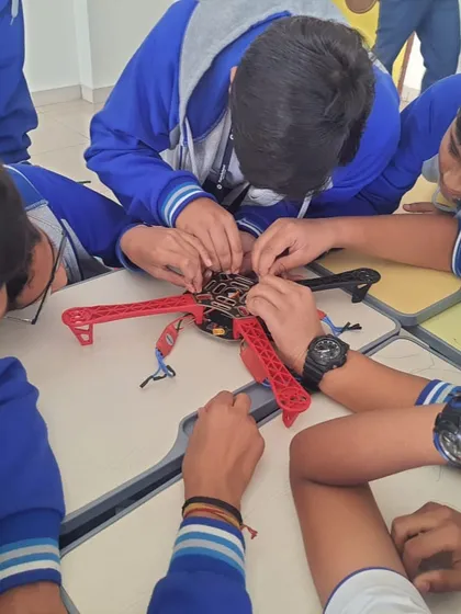 Students get hands-on experience with advanced technology like drones. Here, a group collaborates to assemble a quadcopter frame during a workshop at Euro International School.