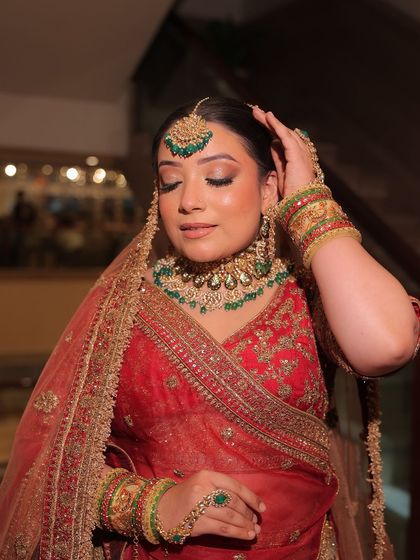 A full bridal look featuring a red lehenga with green-accented kundan jewellery. These images show how you can create a perfectly coordinated and stunning bridal look through my rental service.