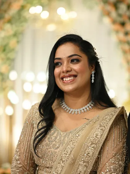 A candid laugh that lights up the room. This bride's Sangeet look features a soft smokey eye and a radiant smile, paired with a glittering gold lehenga and diamond jewelry.
