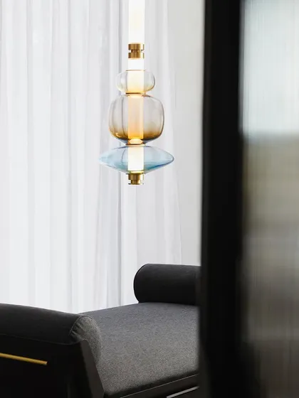 The beautiful form of a Luna Kaleido pendant seen against the soft, diffused light of a curtained window. The interplay of natural and artificial light is a key part of my design philosophy.