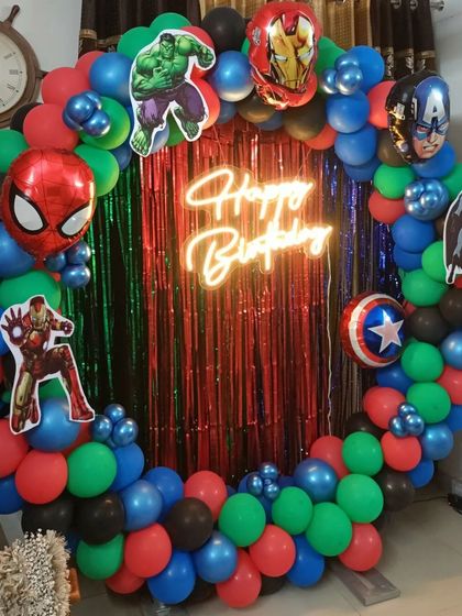 An action-packed Avengers theme, using a ring frame filled with a multi-color balloon garland and cutouts of heroes like Spider-Man, Hulk, and Captain America.