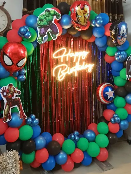 An action-packed Avengers theme, using a ring frame filled with a multi-color balloon garland and cutouts of heroes like Spider-Man, Hulk, and Captain America.