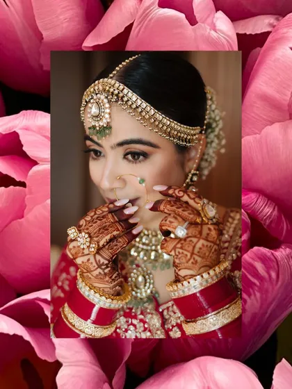 A beautiful close-up of a bride, her hands framing her face, framed by a vibrant pink floral border.