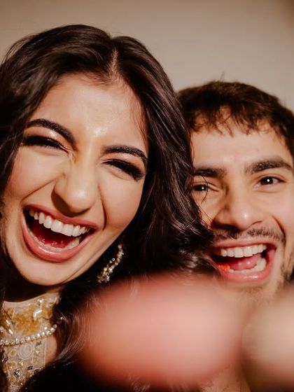 A fun, candid selfie-style shot of the couple, full of laughter and energy.