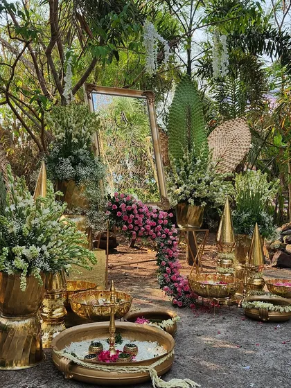 The intricate arrangement of brass decor, flowers, and mirrors creates a luxurious and traditional welcome for guests.