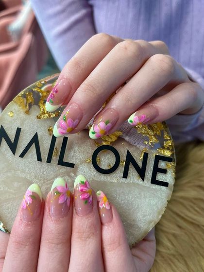 A closer view of the delicate pink floral nail art, highlighting the detailed brushstrokes and the subtle color blending within each petal.