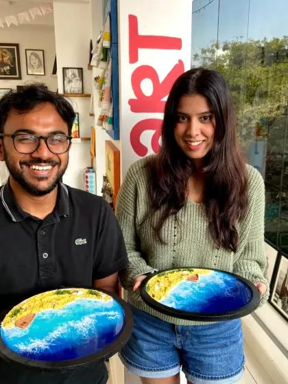 A couple proudly holds up their finished resin beach art. It's a great way to create a shared memory and a beautiful piece of art.