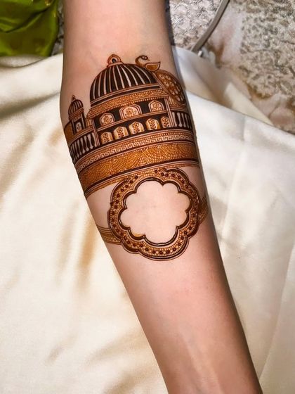 The beginning stages of a Ganesha portrait on the forearm, with the architectural outline already in place.