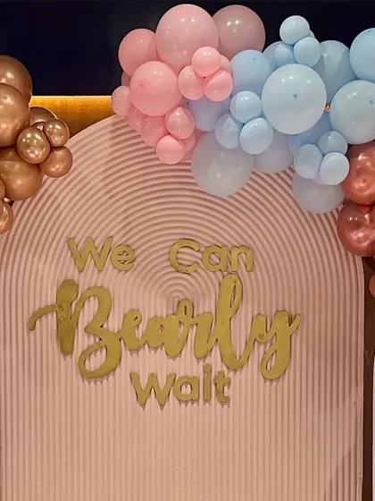 A close-up of our 'We Can Bearly Wait' baby shower theme. This design uses 3D lettering on a textured backdrop, framed with organic balloon clusters in rose gold, bronze, pink, and blue for a chic and modern celebration.
