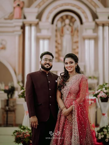 The couple posing inside a church, their formal reception attire looking elegant against the grand backdrop.