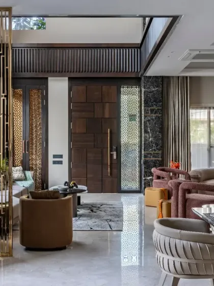 A closer look at the entrance of this living space, where a custom wooden door and intricate metal screen set a luxurious tone. The design ensures that every element, from the entrance to the seating, contributes to a cohesive aesthetic.