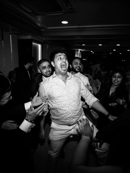 A candid and funny moment from the dance floor, as guests lift a friend up in celebration.