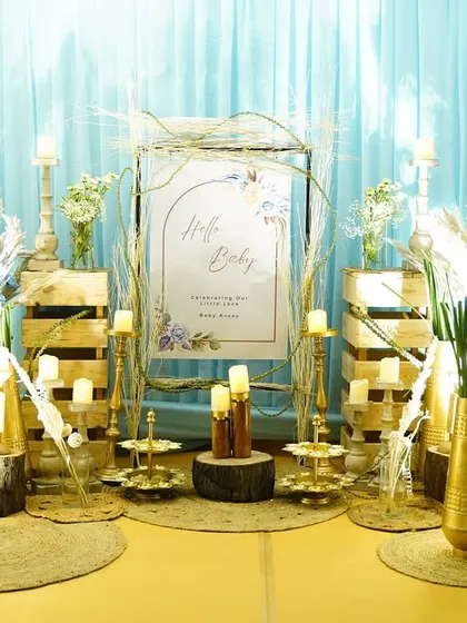 The welcome and gift area for the party. We used rustic elements like wooden crates and jute mats, combined with elegant brass candle holders and pampas grass, to create a stylish, layered look.