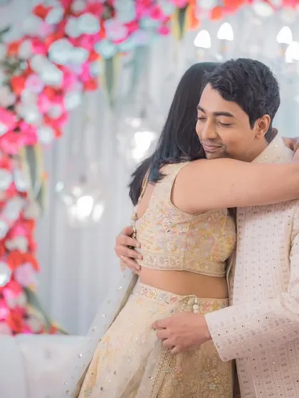 An emotional, candid moment of a warm hug between family members at an engagement party.