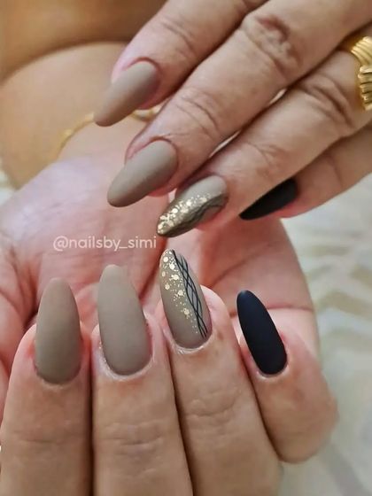Matte nails make designs pop so much! This set features a mix of beige and black matte polish with gold foil and line art.