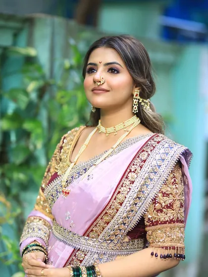 A three-quarter profile highlighting the soft contouring and the intricate details of the blouse and jewelry.