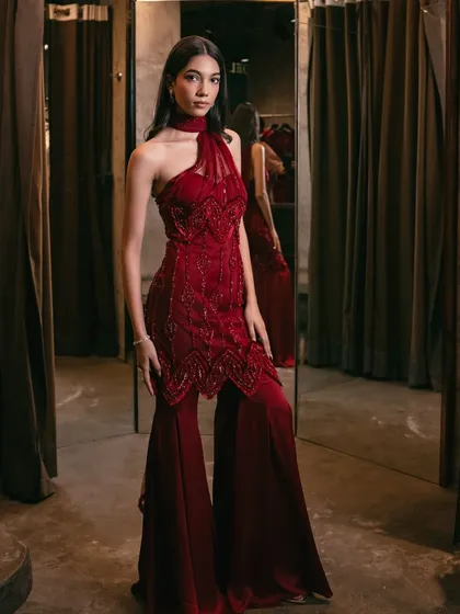 The full view of the crimson one-shoulder sharara set, the epitome of modern elegance for the festive season.