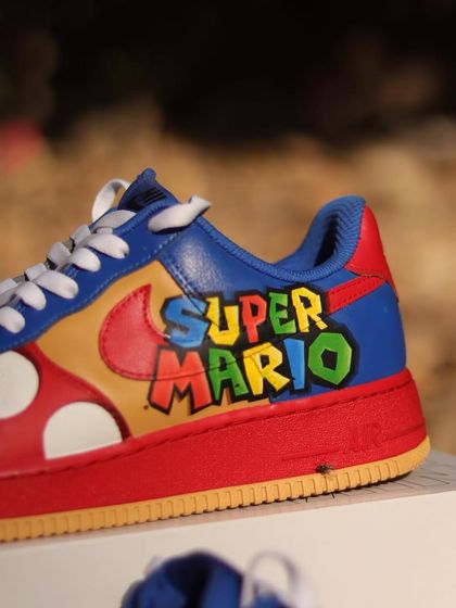The other side of the Super Mario AF1s, featuring the classic game logo. The bright, blocky letters and primary colors are instantly recognizable and bring a sense of fun and nostalgia.