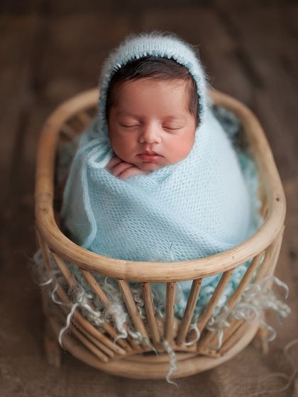 This is my own son, Caden. I started collecting props for him in my second trimester. This light blue wrap and bonnet in a rattan bassinet was one of the many setups I dreamed of for him.