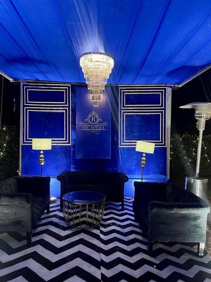 A chic lounge area for "The Royals" NYE party. The royal blue velvet, chevron-patterned rug, and grand chandelier created a sophisticated and comfortable space for guests to relax.