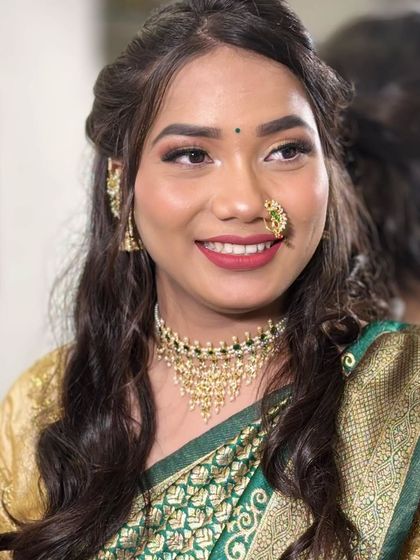 Her happy smile says it all! The jewellery perfectly complements her festive green and gold saree.