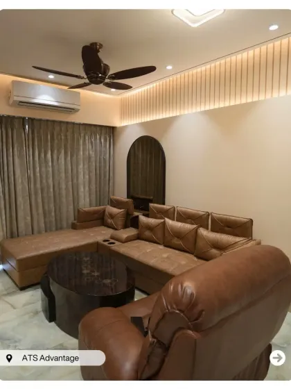 This living room at ATS Advantage combines a plush leather recliner and sectional sofa for ultimate comfort. The fluted wall paneling and arched mirror add texture and modern elegance.