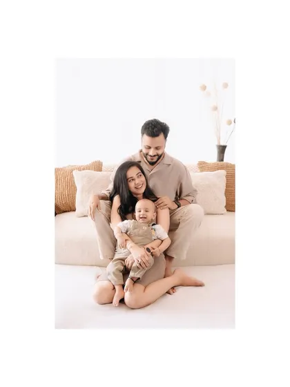 A beautiful, bright family portrait. The clean, minimalist setup allows the family's joy and connection to be the complete focus of the photograph.